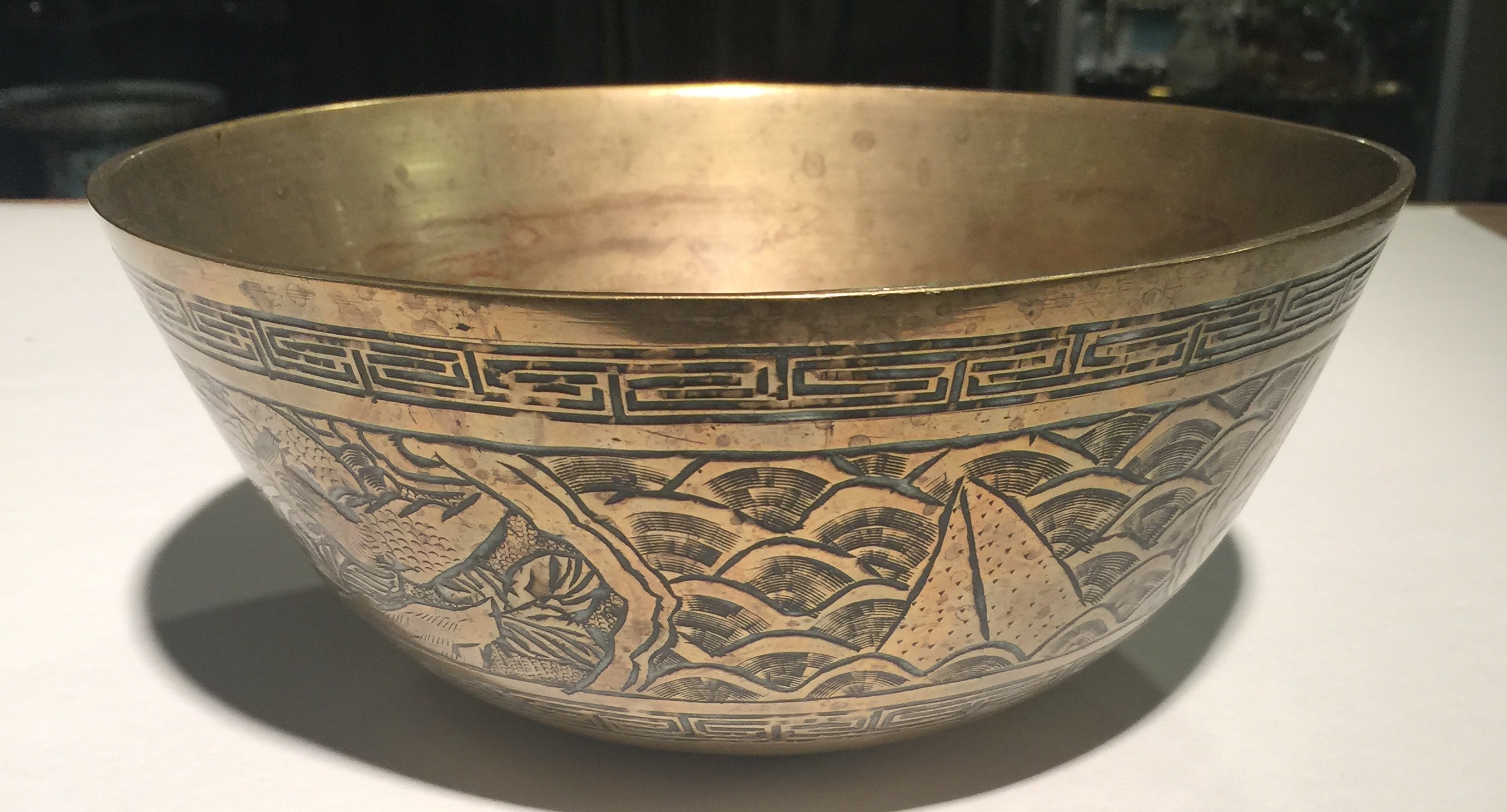 A HEAVY ANTIQUE CHINESE BRONZE BOWL With chased and engraved decoration, in the form of mythical