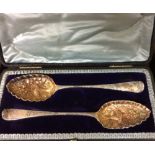 A PAIR OF LATE 19TH CENTURY SILVER GILT BERRY SPOONS Serrated edges with gilt embossed design, of