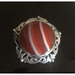 A SCOTTISH SILVER AND AGATE BROOCH FROM JONA The circular polished agate plaque collet set to an