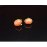 A PAIR OF 19CT GOLD AND CORAL EAR STUDS Small, oval red coral cabouchons collet set in gold to
