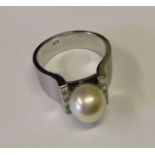 AN 18CT GOLD RING With a large central pearl and baguette cut diamonds, stamped '18k'.