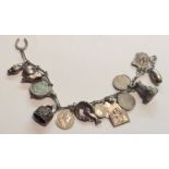 AN EARLY 20TH CENTURY CONTINENTAL SILVER CHARM BRACELET Having various silver coins, 1 dime, 1886, 5
