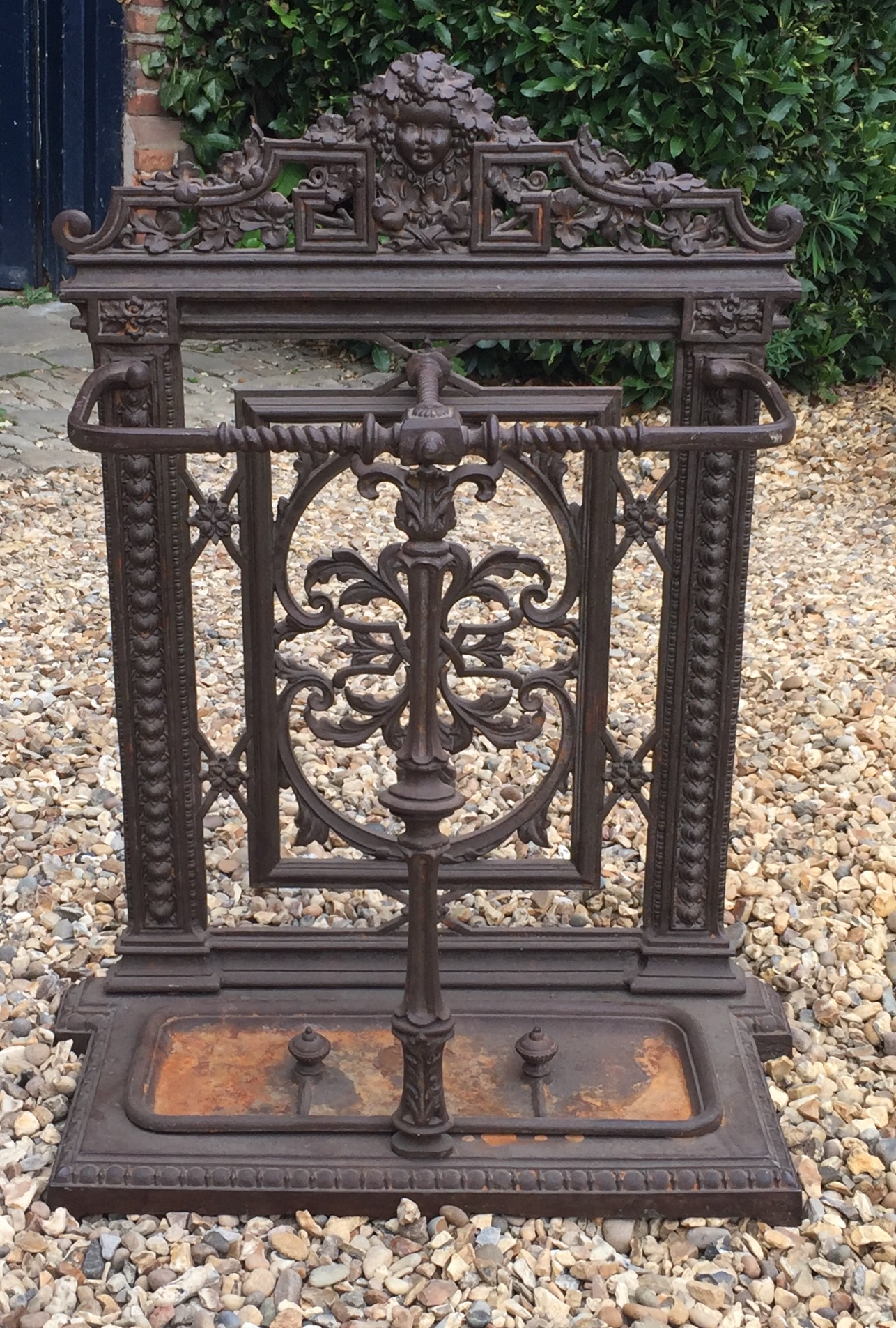A 19TH CENTURY CAST IRON COALBROOKDALE DESIGN DOUBLE STICK STAND Decorated with a cherub mask