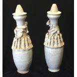 A PAIR OF SONG DYNASTY 960-1127 PALE CELADON VASES AND COVERS Banded with human burial figures and