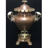 A VICTORIAN POLISHED COPPER TWO HANDLED TEA URN. (44cm)