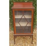 AN EDWARDIAN MAHOGANY AND CROSSBANDED DISPLAY CABINET With astragal glazed door, raised on square