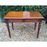 A 19TH CENTURY OAK WRITING TABLE The rectangular top with two short drawers, flanked by carved