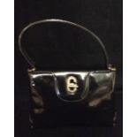 GUCCI, A VINTAGE MID 20TH CENTURY STRUCTURED BLACK PATENT LEATHER HANDBAG Having three internal