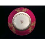 AN EARLY 19TH CENTURY ENGLISH POTTERY ARMORIAL PLATE The red border with gilt floral decoration, the