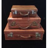 THREE VINTAGE LEATHER SUITCASES OF GRADUATED SIZES The largest bearing the initials 'B.I.E.',