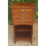 AN EDWARDIAN MAHOGANY MUSIC CABINET With four fall front drawers with brass handles, above shelves.