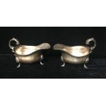 A PAIR OF HEAVY EDWARDIAN SILVER SAUCE BOATS With gadrooned border and scrolling handle with