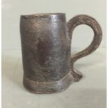 A 17TH/18TH CENTURY LEATHER TANKARD With tapering body and integral loop handle, projecting into a