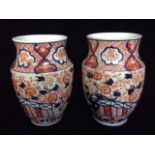 A PAIR OF 19TH CENTURY JAPANESE IMARI PORCELAIN BALUSTER VASES Hand painted with floral cartouches