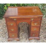 A 19TH CENTURY MAHOGANY KNEEHOLE DESK With brushing slide over an arrangement of seven drawers,