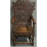 A 17TH CENTURY AND LATER OAK WAINSCOT OPEN ARMCHAIR The carved panel back with facial mask and