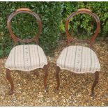 A PAIR OF VICTORIAN MAHOGANY BALLOON BACK CHAIRS With carved rail over a needlework upholstered