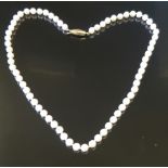 A STRING OF UNIFORM CULTURED PEARLS With a 9ct gold clasp, the knotted string of 6mm pearls to a