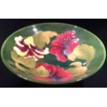 WALTER MOORCROFT POTTERY, A 20TH CENTURY TAZZA DISH Hibiscus pattern, with a tubelined decoration of