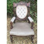 A LATE VICTORIAN WALNUT OPEN ARMCHAIR In mushroom velvet button back upholstery.