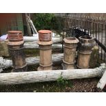 A SET OF FOUR VICTORIAN CAST STONE CHIMNEY POTS. (97cm)