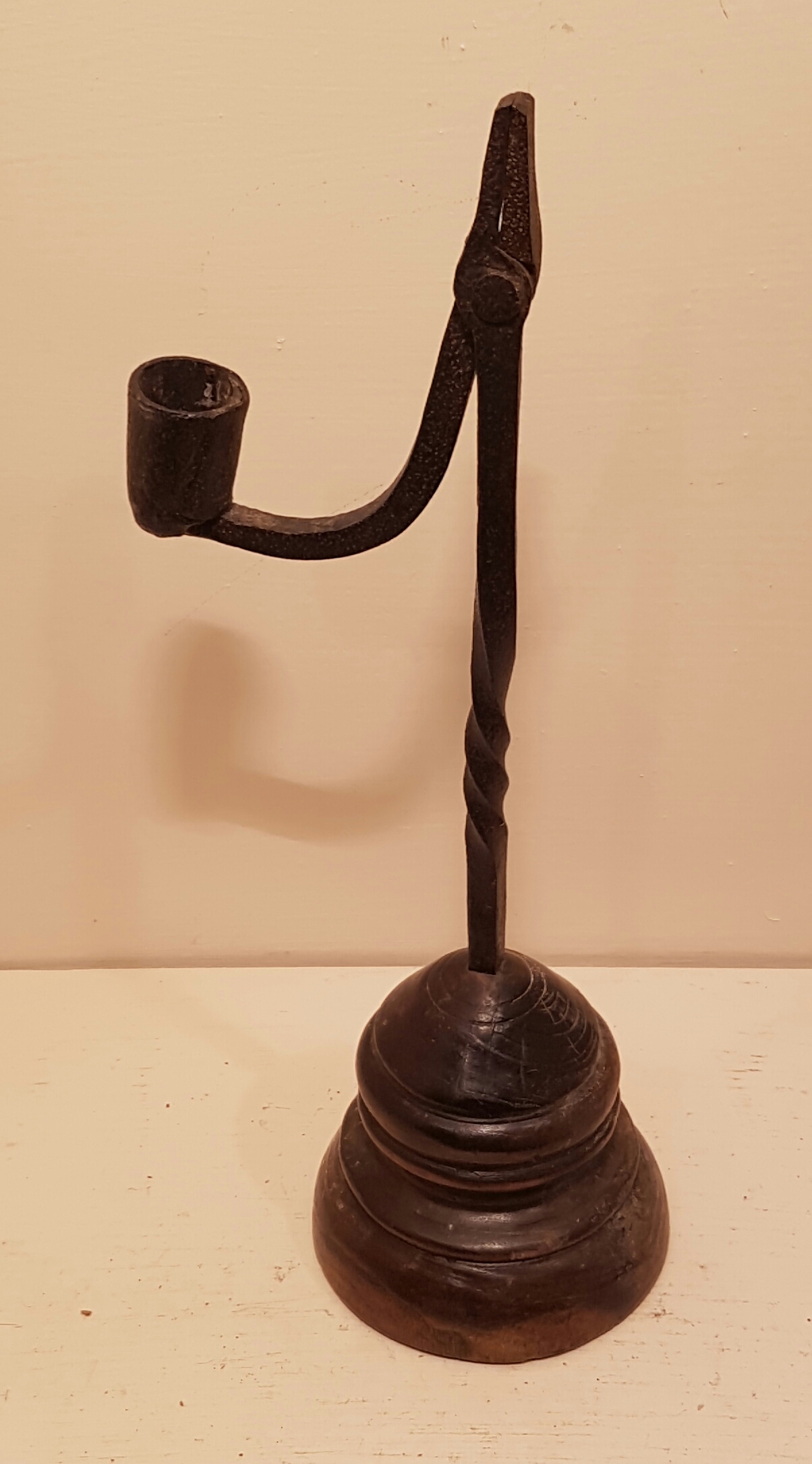 AN IRON TABLE RUSHLIGHT AND CANDLE SOCKET With partial spiral twist stem, set on a turned and
