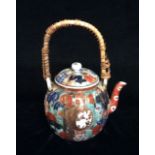 A 19TH CENTURY JAPANESE IMARI PORCELAIN TEA KETTLE Bamboo handle on a fluted circular body, hand