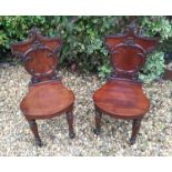 A PAIR OF WILLIAM IV MAHOGANY HALL CHAIRS The backs carved with stylized organic form over shaped