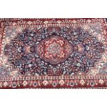 TWO 20TH CENTURY PERSIAN WOOLLEN RUGS To include a blue and red lozenge shape central field and