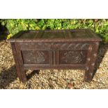 A 17TH/18TH CENTURY OAK COFFER The panelled top and sides carved with stylized flowers and