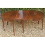 A GEORGIAN MAHOGANY 'D' END DINING TABLE With one extra leaf, raised on square section tapering