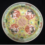 A CHINESE PORCELAIN BOWL Having a yellow ground with bats hand painted with four red cartouches,