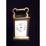 AN EARLY 20TH CENTURY FRENCH GILT BRASS CARRIAGE CLOCK With carry handle, the oval glass aperture