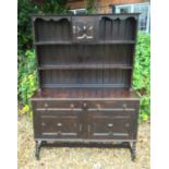 AN EARLY 20TH CENTURY JACOBEAN DESIGN OAK DRESSER The open shelves above two short drawers over