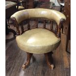 A VICTORIAN WALNUT AND BEIGE UPHOLSTERED CAPTAIN'S CHAIR With turned baluster spindle rails,