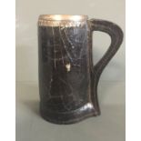 A 17TH/18TH CENTURY ENGLISH TANKARD The engraved silver rim over tapering body with stitched