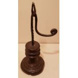 AN 18TH CENTURY IRON TABLE RUSHLIGHT With a spiral stem and extended bracket arm, the scroll