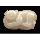 A CHINESE WHITE AND RUSSET JADE CARVING Of a young boy in a sleeping position, with folded arms