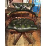 A 20TH CENTURY CAPTAIN'S CHAIR In green leather button back upholstery, on a swivel base.