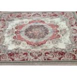 A LARGE 20TH CENTURY AUBUSSON WOOL RUG Having a central field decorated with a bouquet of flowers,