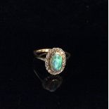 A 14CT GOLD DIAMOND AND OPAL RING The central oval cabochon cut opal collet set and surrounded by
