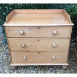 A VICTORIAN PINE CHEST OF DRAWERS The galleried top above three long graduated drawers, raised on