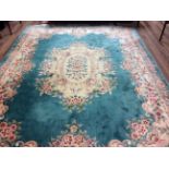 A LARGE CHINESE WOOLEN RUG OF CARPET PROPORTIONS The central floral cartouche and border on a