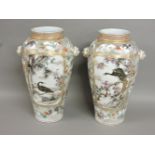 A pair of large Japanese porcelain baluster vases, with lion mask handles either side, and decorated