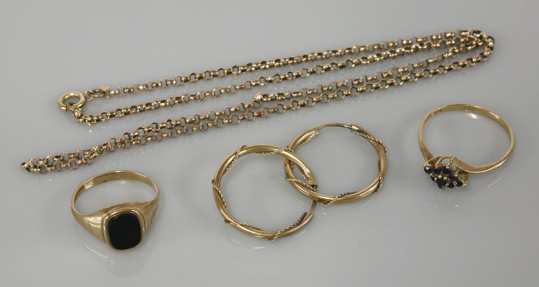 A 9ct gold onyx signet ring, a 9ct gold sapphire cluster ring, a pair of gold hoop earrings marked