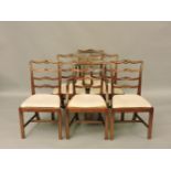 A set of sixteen George III style mahogany dining chairs, with pierced wavy ladder backs and drop in