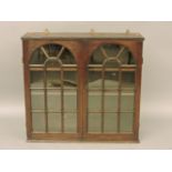 An 18th century oak bookcase cabinet, with two arched astragal glazed doors, a glass pane etched '