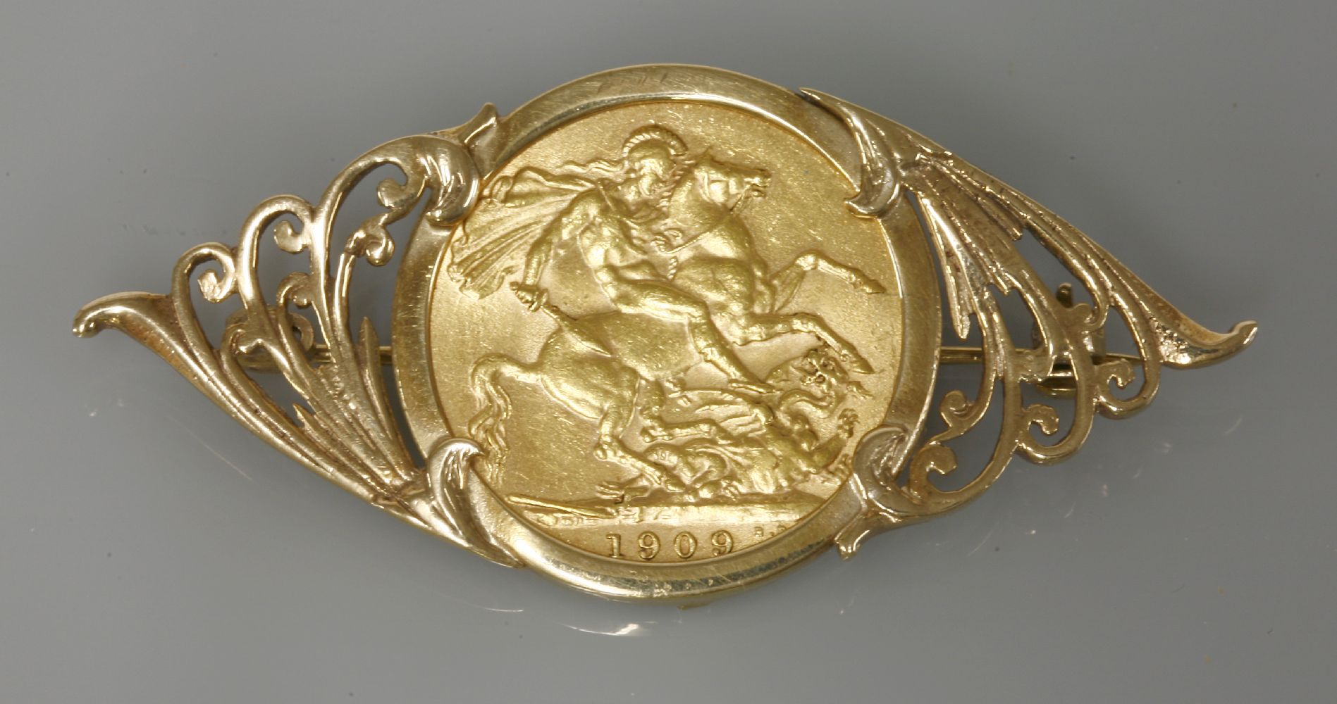 A full sovereign, dated 1909, in a 9ct gold brooch mount