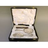 A silver four piece dressing table set, by W I Broadway & Co, Birmingham 1979, decorated with