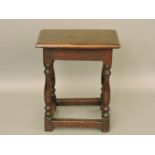 An 18th century oak joint stool, the rectangular top with moulded edge, upon turned legs united by